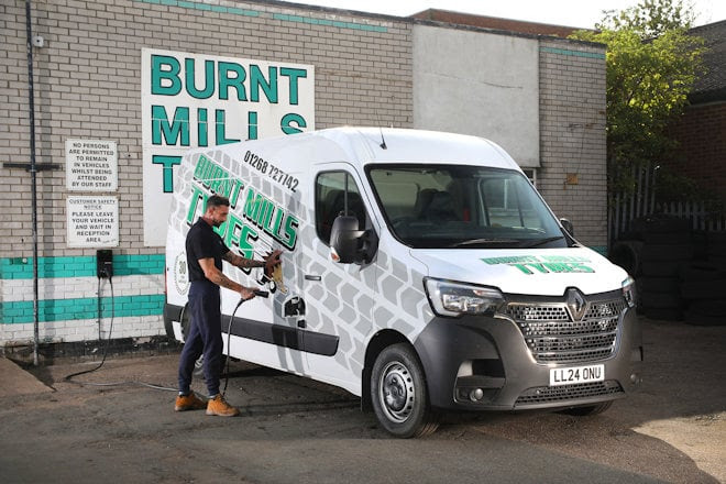 Employee from burnt mills tyres charging electric van