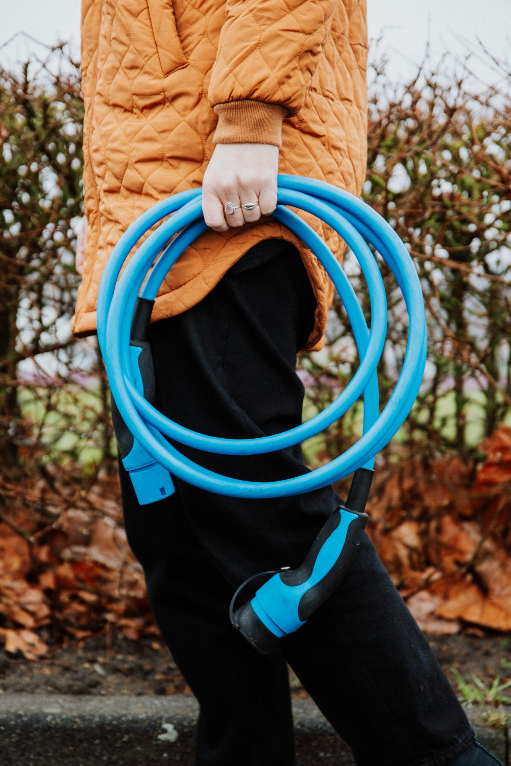 Person holding an electric vehicle charging cable