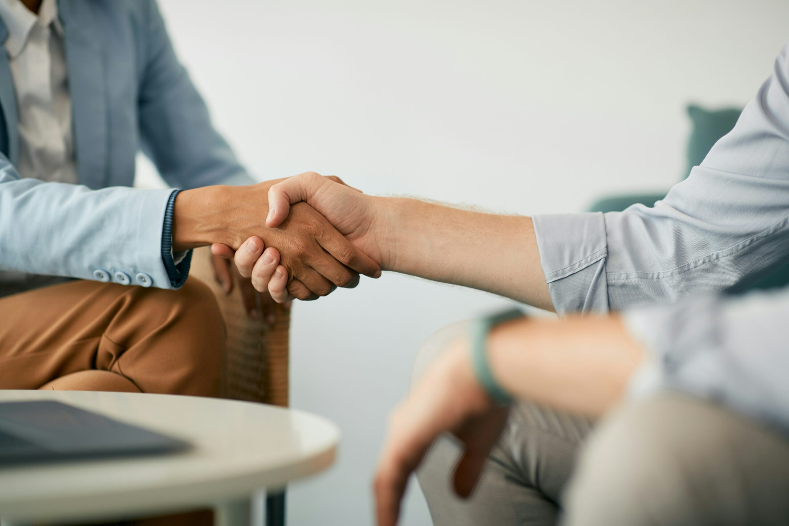 Two people sitting down and shaking hands