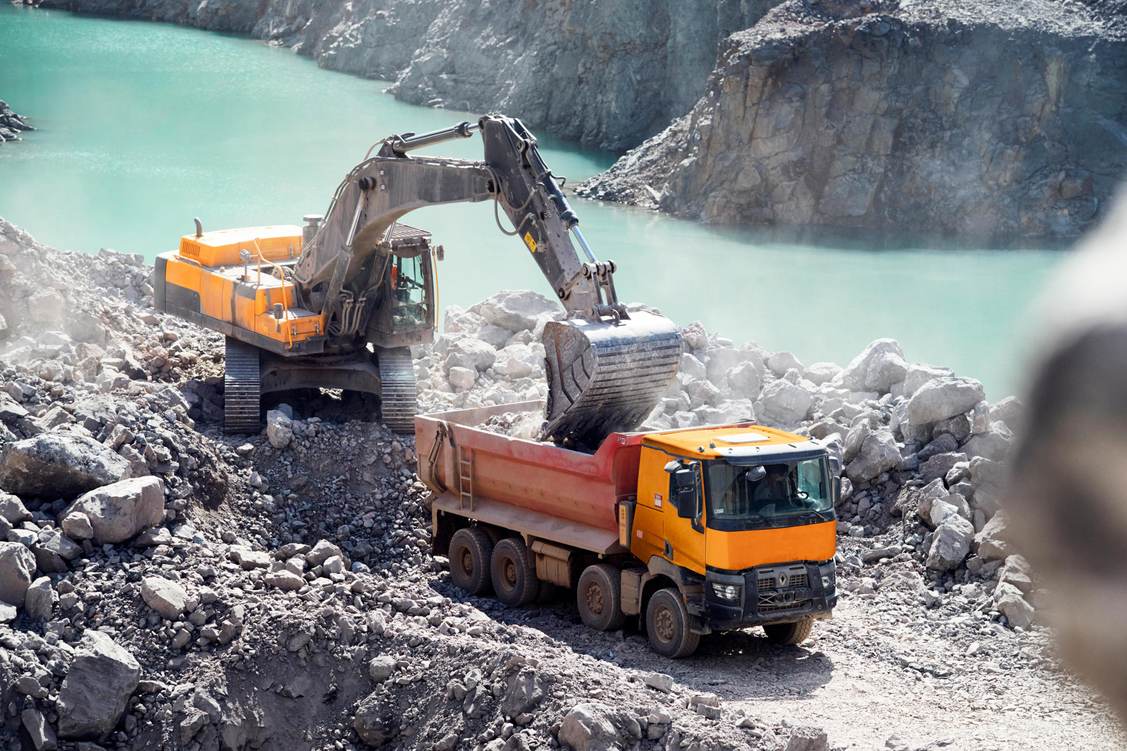 Digger loading into a Renault Trucks K in quarry