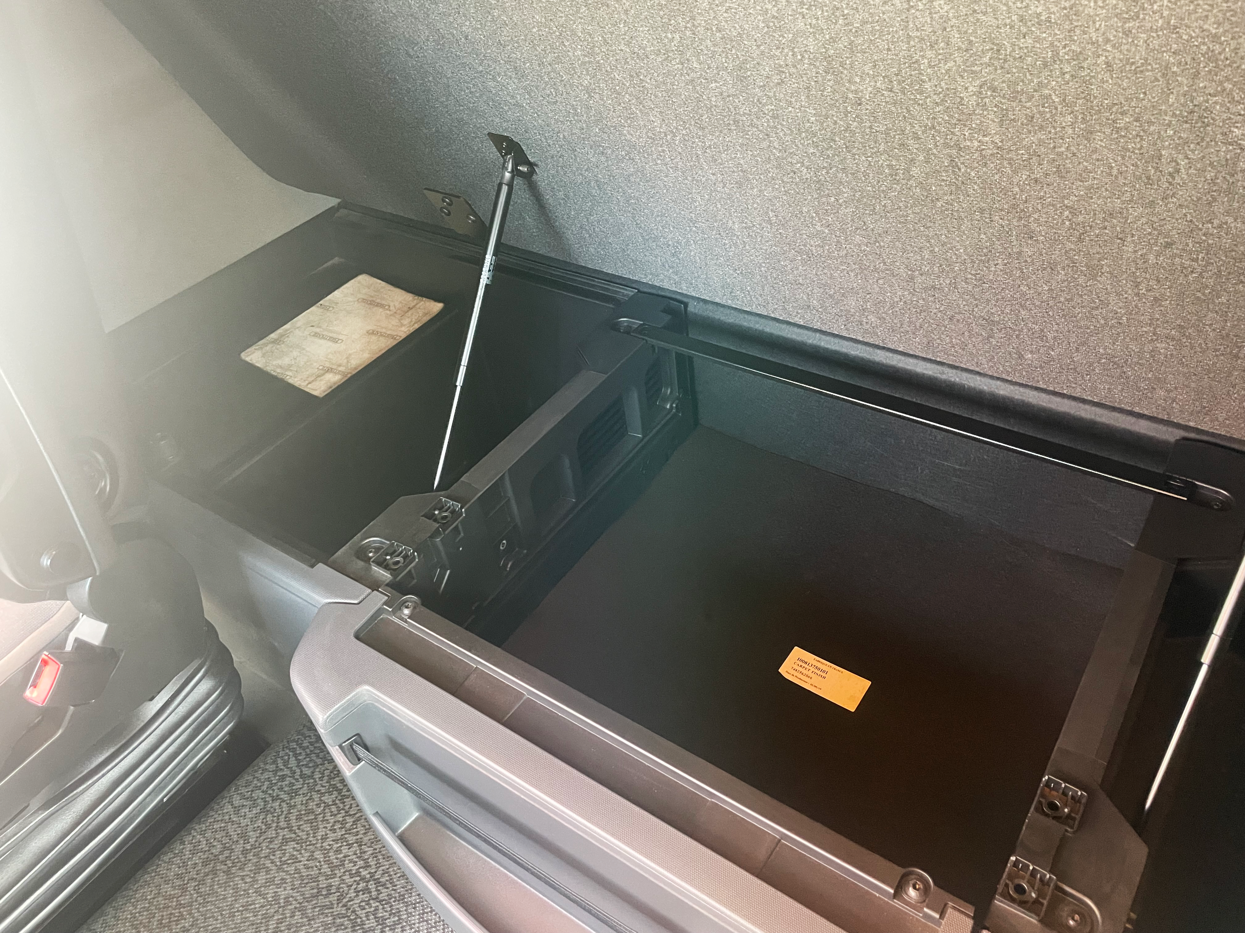 Under-bed storage compartment open inside Renault Trucks T 460 cab, showing practical built-in storage solution