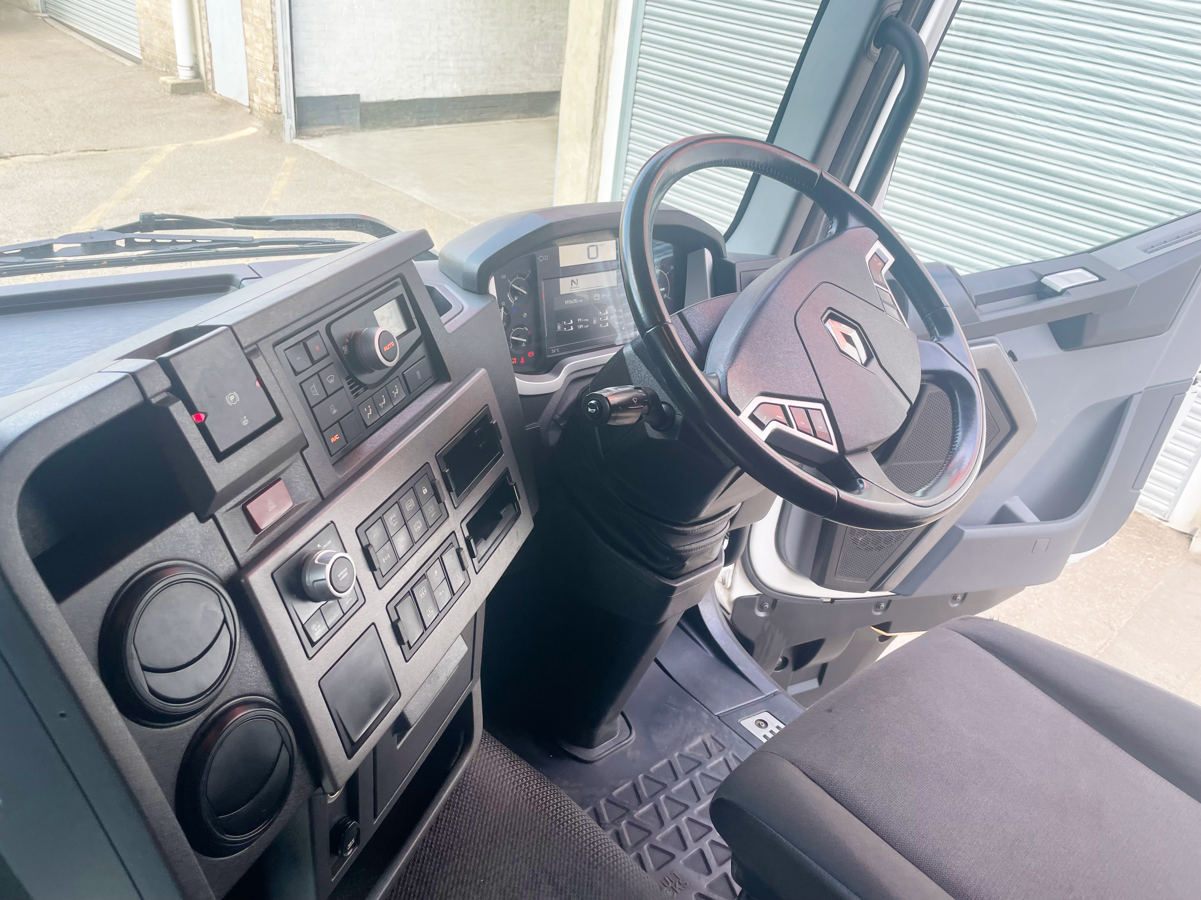 Interior cab view of Renault Trucks T 460 from passenger side door, showing dashboard layout and steering wheel