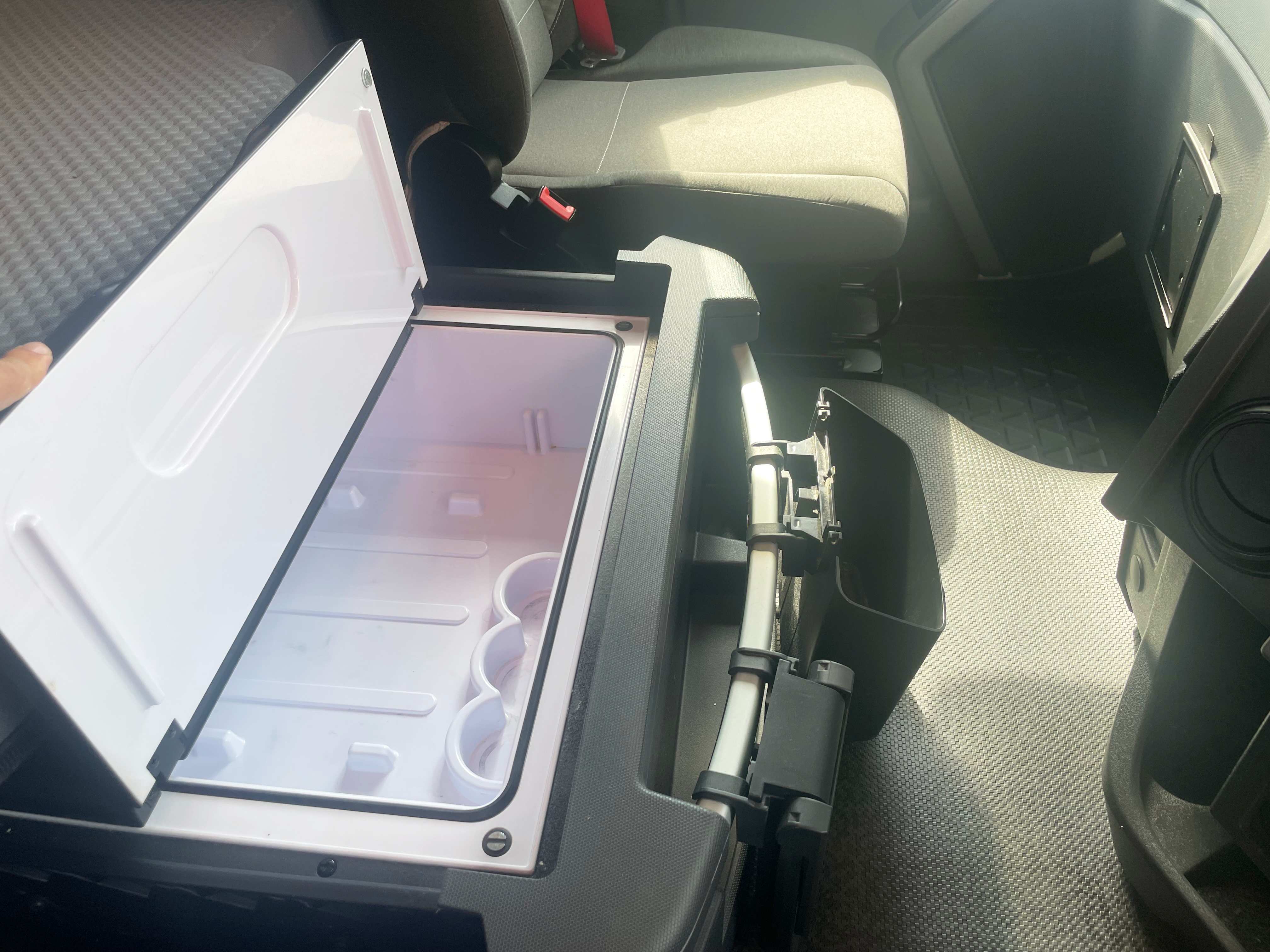 Open in-cab fridge in Renault Trucks T 6x2 Euro 6 sleeper cab, showing interior storage space next to passenger seat.