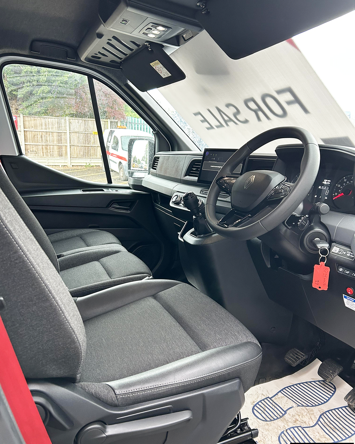 Driver's cab of Renault Master 150 featuring multifunction steering wheel, touchscreen display and three-seat layout.