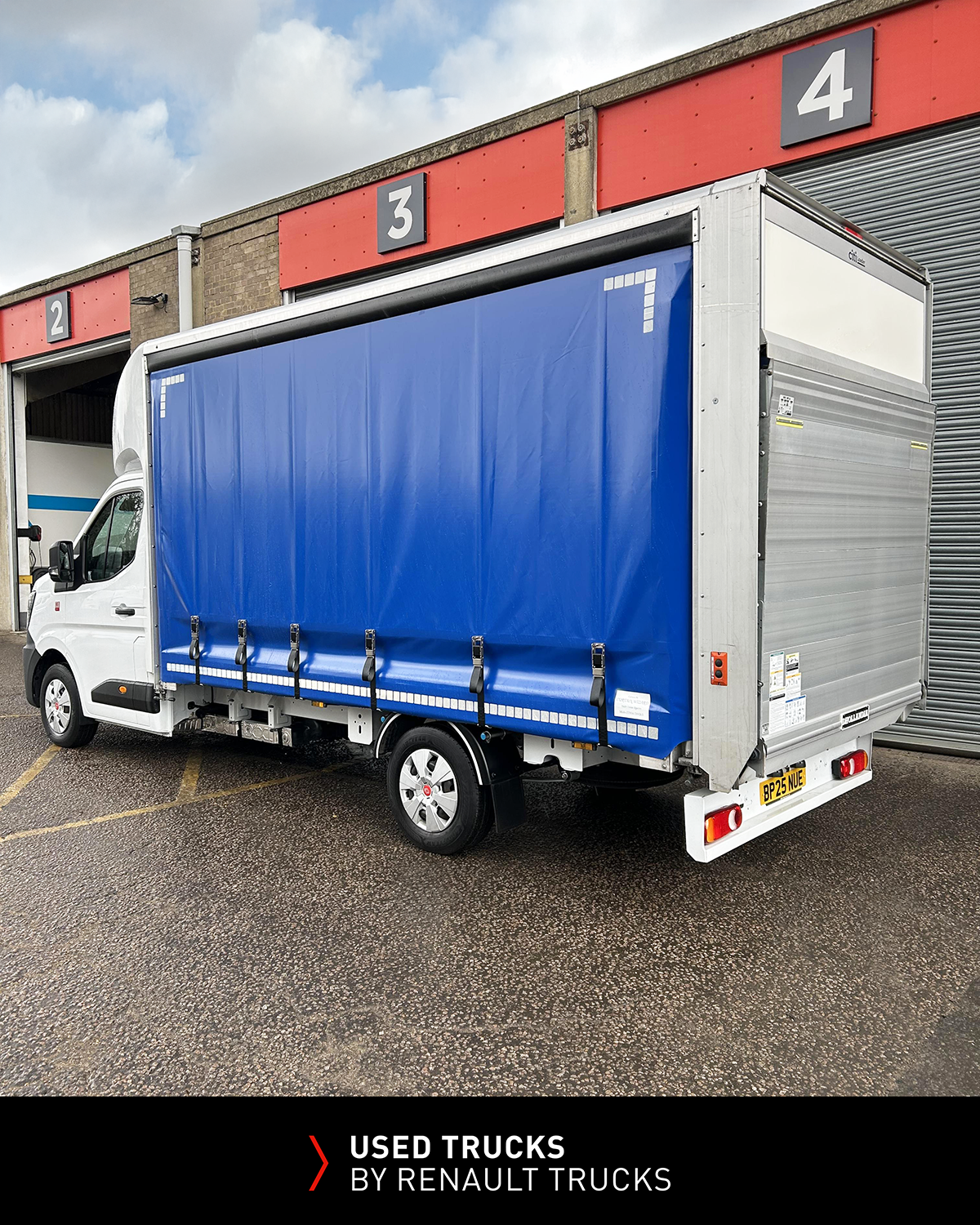 Rear three-quarter view of a Renault Master curtainsider showing Dhollandia tail lift and curtain-sided load body.