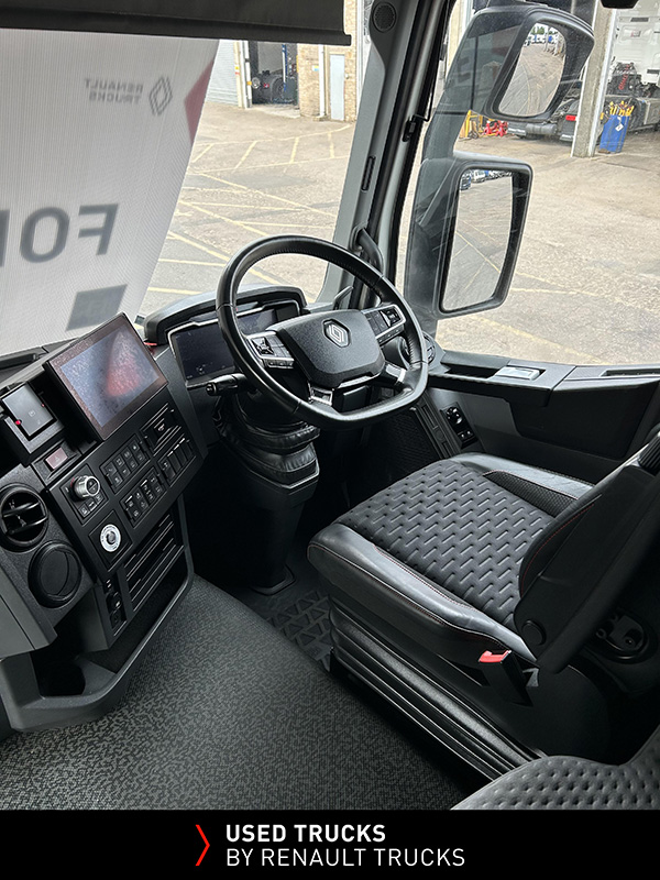 Driver's seat, steering wheel and dashboard inside the Renault Trucks T480 sleeper cab.